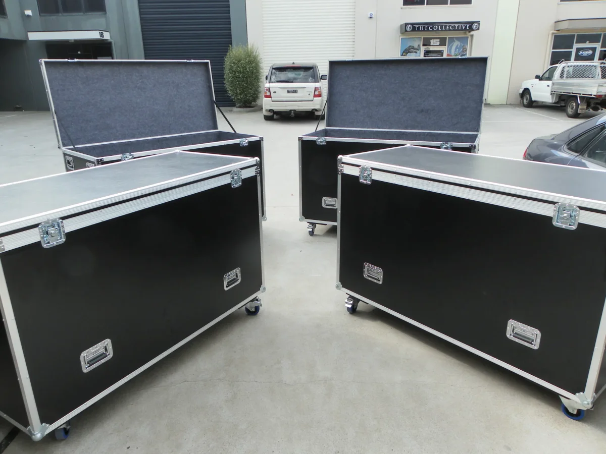 Four road cases staged outside, two with lids open showing carpet-lined interiors