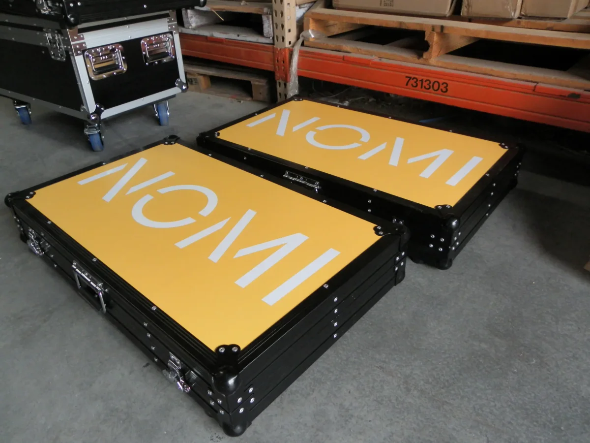 Pair of shallow black flight cases with yellow branded lid panels