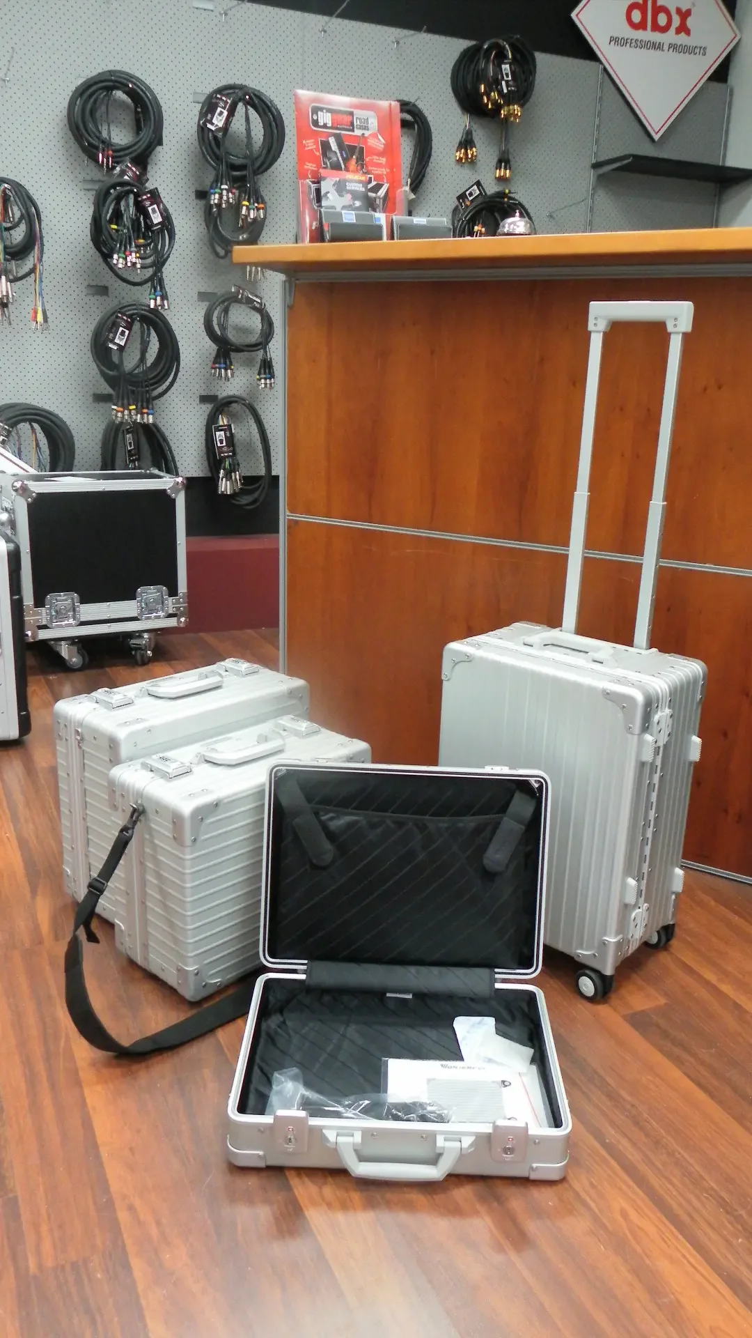 Silver aluminium cases in a range of sizes, including a wheeled case with a telescopic handle