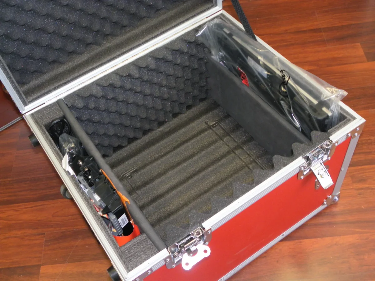 Open red case with convoluted foam lining and a packed camera and tripod rig