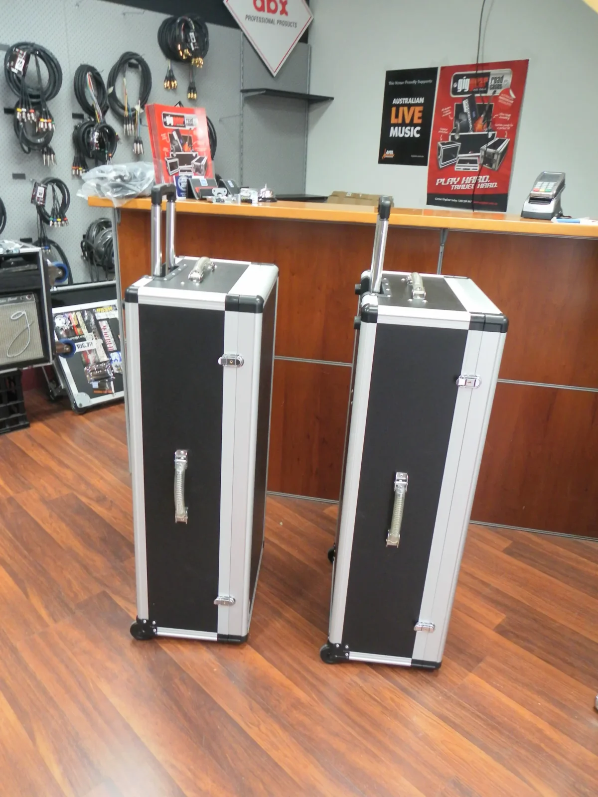 Pair of upright black trolley cases with extended pull handles and side carry handles