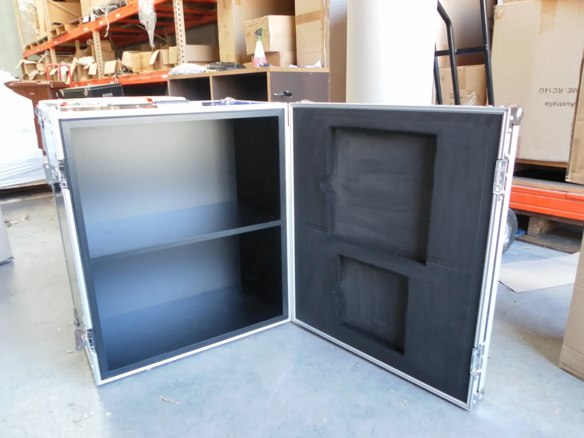 Cabinet style flight case opened flat, one half shelved, the other foam recessed