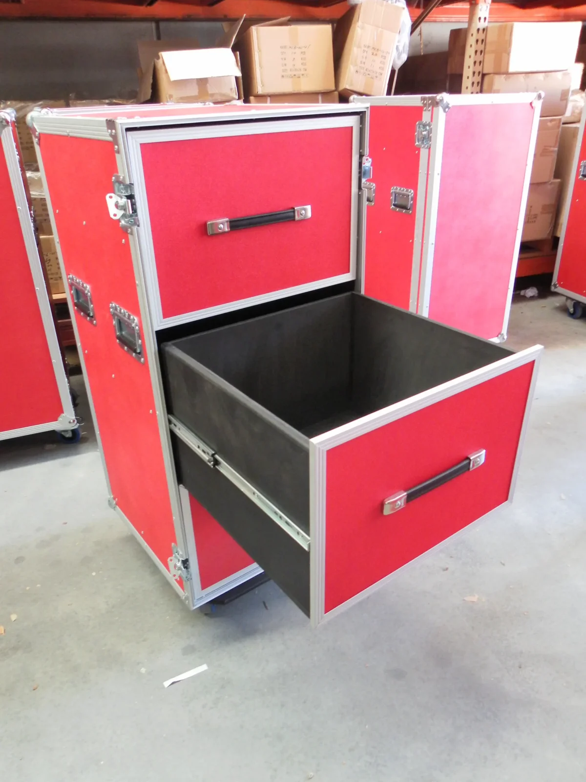 Red road case with the deep lower drawer extended, showing the lined interior