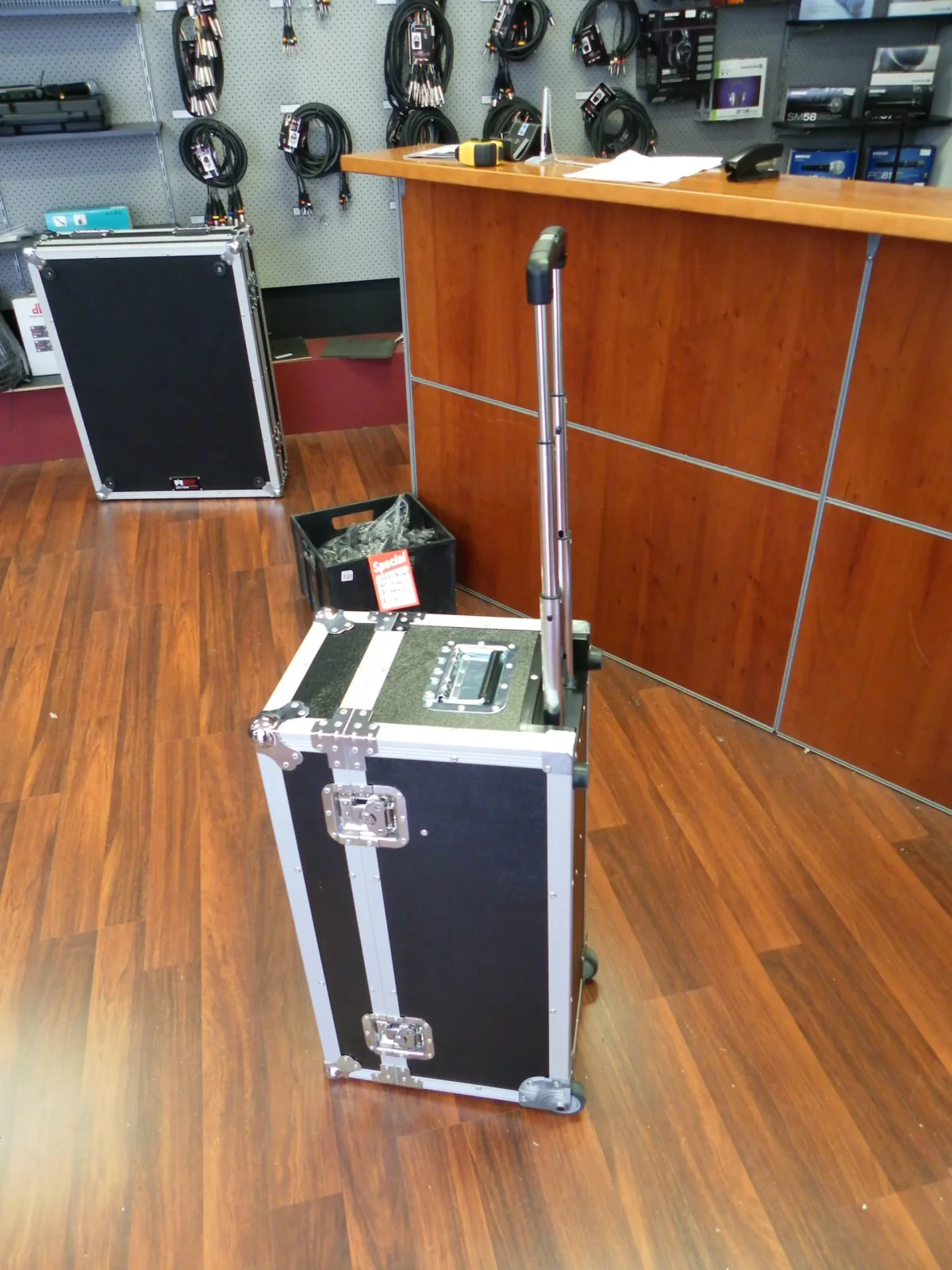 Upright black trolley flight case with its pull handle extended