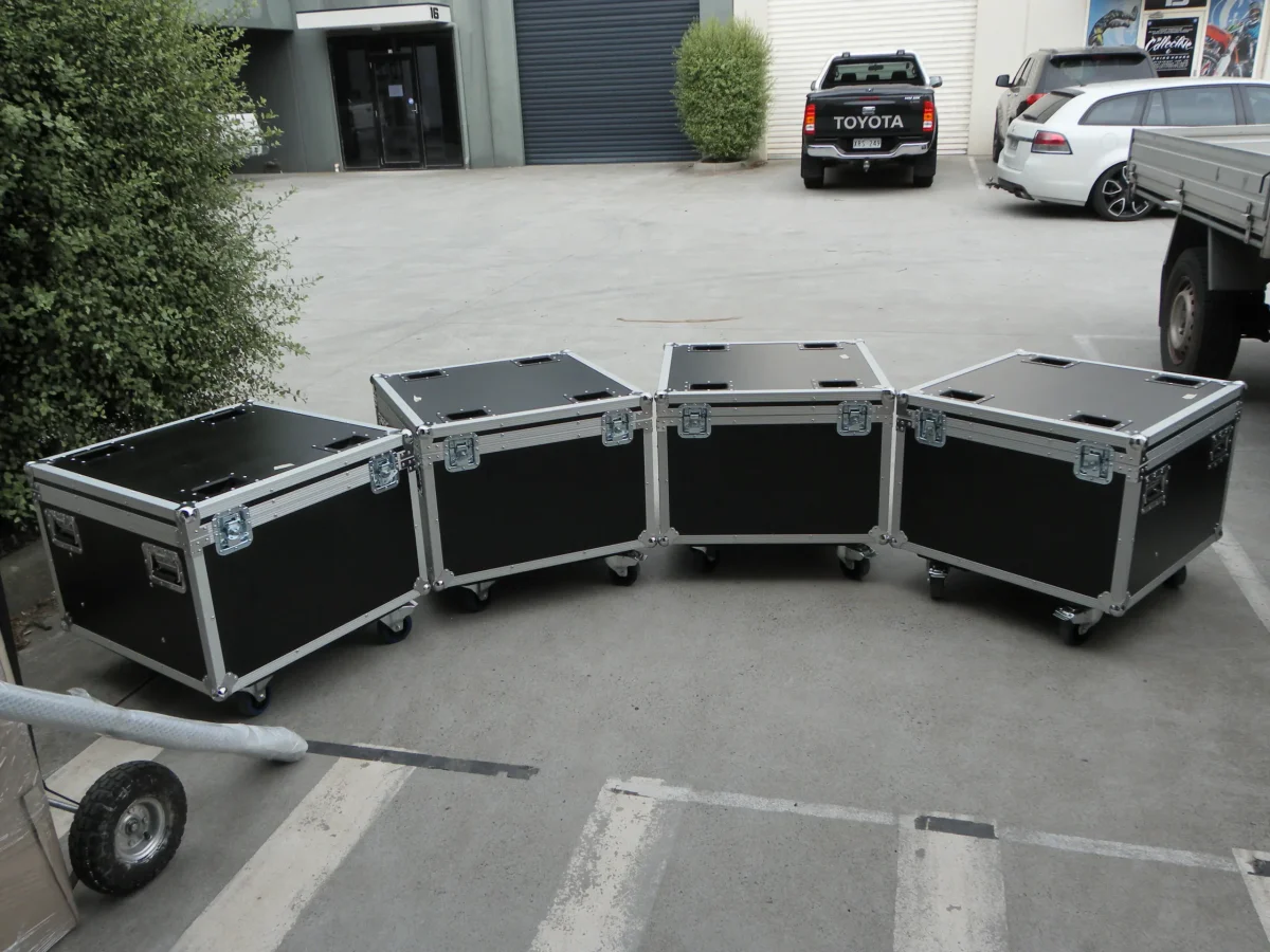 Four matching road cases with lids closed, staged in the yard before dispatch