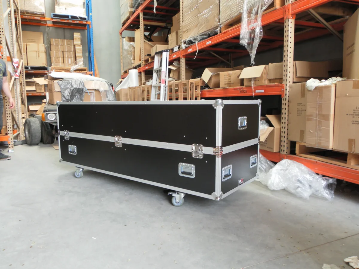 Long road case with twin lid catches, staged in the warehouse racking aisle