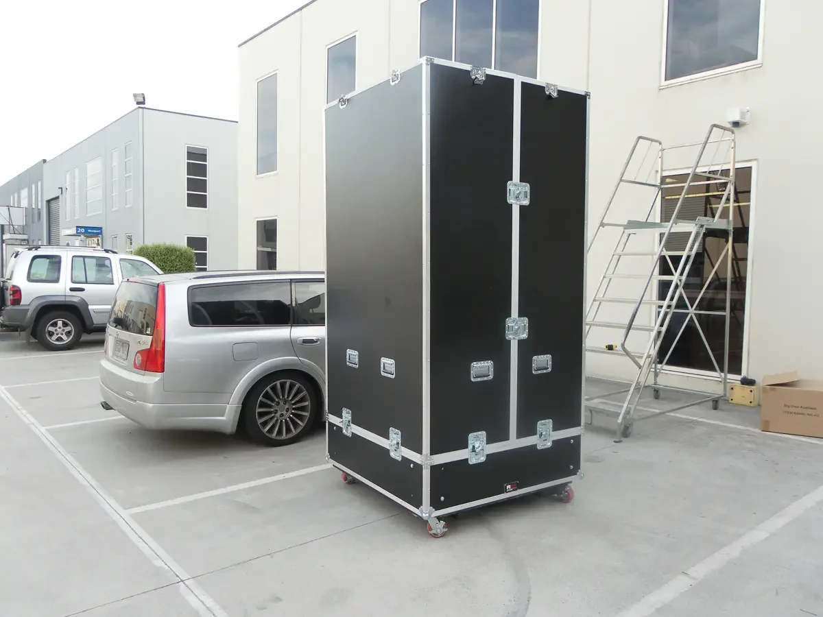 Tall wardrobe-style road case on castors outside the workshop