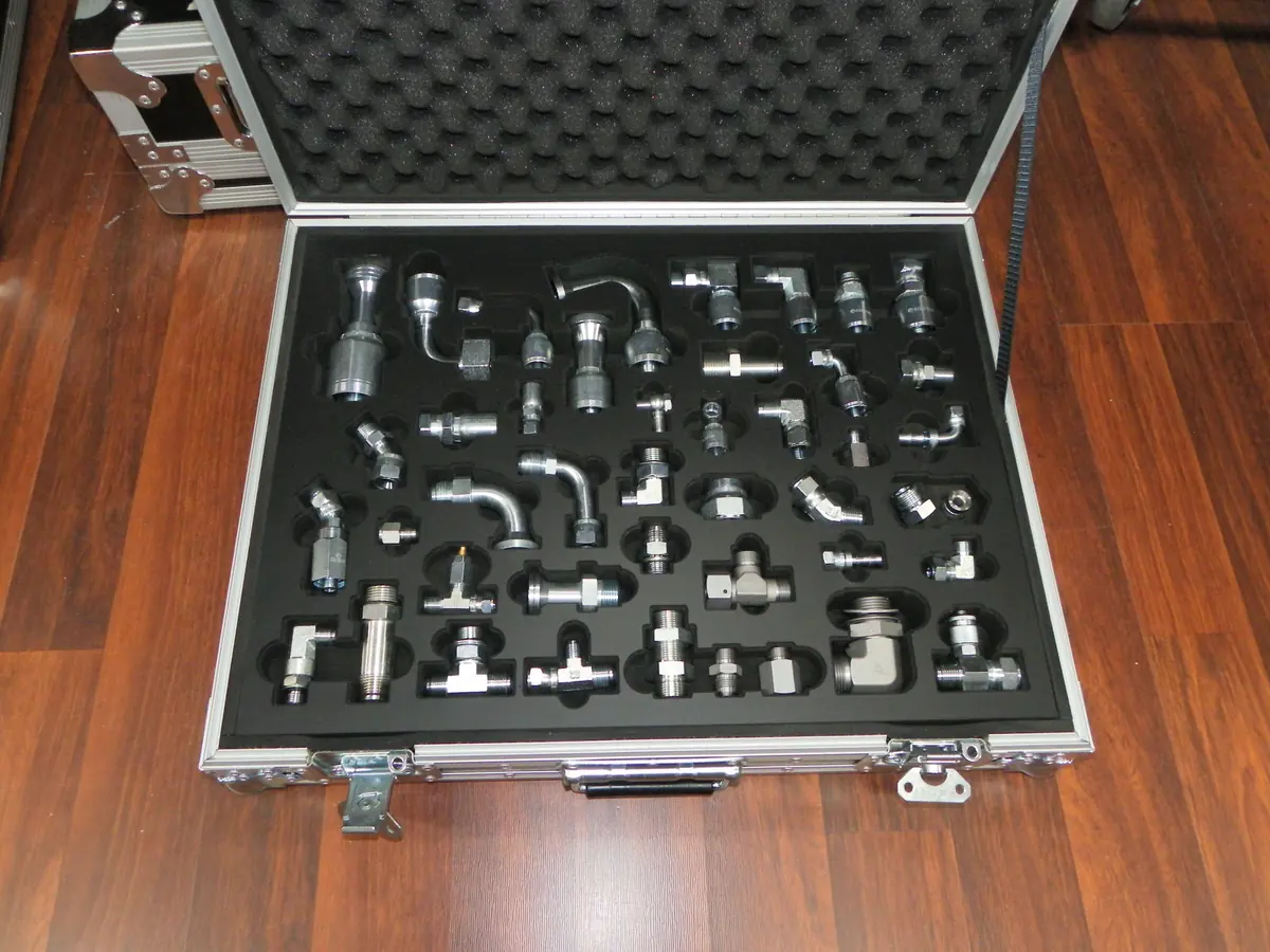 Heavy duty briefcase open to show a CNC cut foam insert holding rows of hydraulic hose fittings